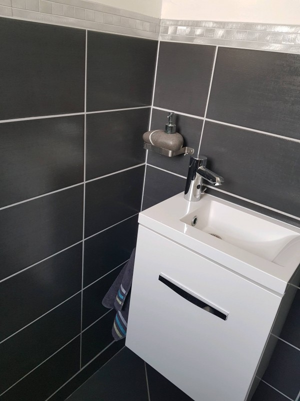 Installation d'un lave-mains dans un wc gris et blanc